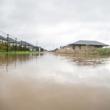 Romainių gyventojai stveriasi už galvų: gatvės virto upėmis, kiemai – ežerais