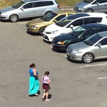 Gudrybė: automobilių aikštelėje besisukiojanti moteris vedžiojosi mažą mergaitę.