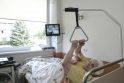 Reabilitacija: Z.Madzajienė, kuriai neseniai implantuotas dirbtinis kojos sąnarys, savarankiškai kyla iš lovos ir eina mankštintis, prižiūrimas medikų.